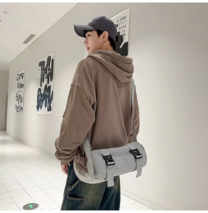 Detailansicht der hellgrauen Zylindertasche aus Nylon mit schwarzen Klickverschlüssen