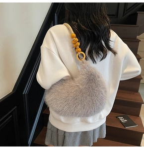 Détail du sac à bandoulière en fausse fourrure grise avec bandoulière tissée et perles bois