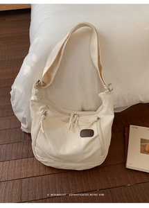 Gros plan du sac bandoulière minimaliste en toile crème avec design fonctionnel multi-poches