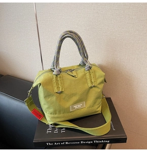 Vue détaillée du sac seau en nylon vert avec poignées en corde tissée et logo de marque
