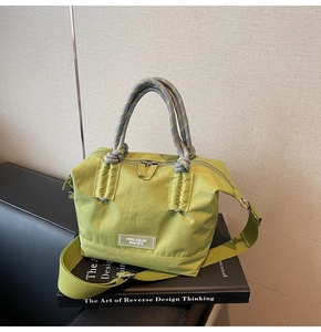 Détail d'un sac seau en nylon vert avec poignée en corde et étiquette transparente
