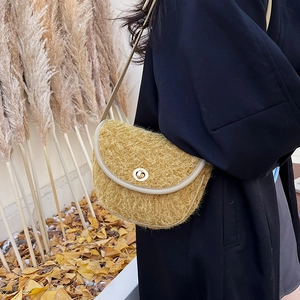 Dettaglio della borsa a sella in peluche zenzero con chiusura a scatto in metallo dorato