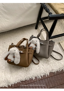 Detail of lychee pattern leather mini bucket bags with rabbit charms and metal buckles