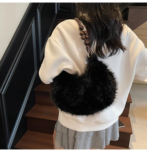 Détail du sac croissant en fausse fourrure noire avec bandoulière en perles de bois