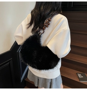 Détail du sac croissant en fausse fourrure noire avec bandoulière décorative en bois