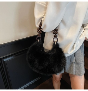 Détail du sac à main en fausse fourrure noire avec poignée en perles de bois et anneaux