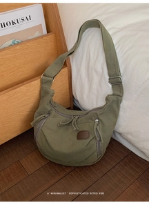 Détail d'un sac hobo en toile vert armée vintage avec bandoulière et patch en cuir