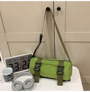 Nahaufnahme der grünen karierten Zylindertasche mit schwarzen Schnallen und Nylonriemen