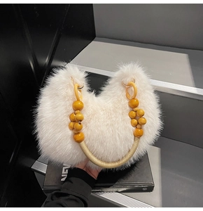 Gros plan du sac en fausse fourrure blanche avec poignée en perles de bois chic