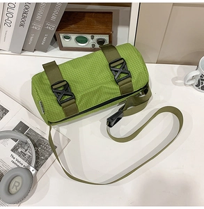 Detail der grünen Zylindertasche aus Gitter-Nylon mit Trägern und Kunststoffschnalle