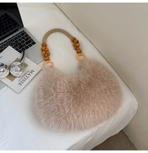 Détail d'un sac à main en fausse fourrure pelucheuse avec poignée en perles de bois et livre