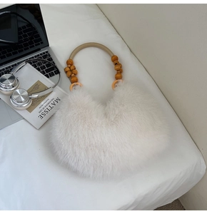 Détail du sac en fausse fourrure blanche avec poignée en bois perlé et décor arty