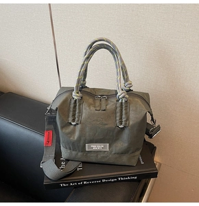 Détail du sac fourre-tout en nylon vert armée avec poignées en corde et bandoulière large