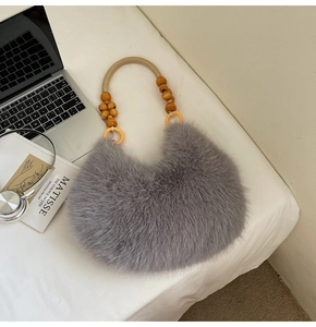 Detail of grey faux fur handbag featuring brown woven handles and decorative wooden beads