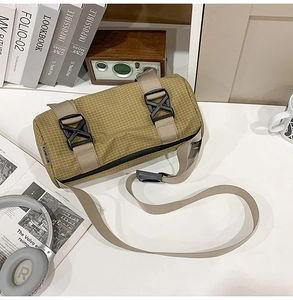 Makro-Detail der gelb karierten Zylindertasche mit technischen Schnallen und Logo