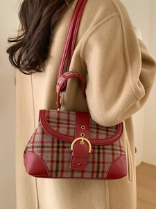 Vintage plaid handbag with red leather trim and gold horseshoe buckle on model
