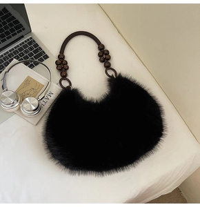 Detail of black faux fur crescent bag featuring stylish wooden bead strap and artistic props