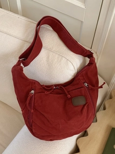Sac hobo en toile bordeaux avec bandoulière large et plusieurs fermetures éclair