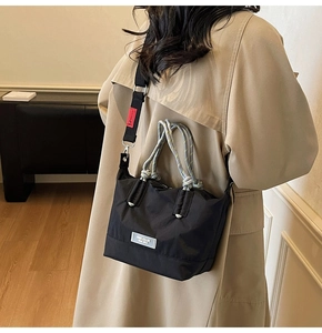 Grand sac fourre-tout en nylon noir avec anses en corde tressée porté par un mannequin