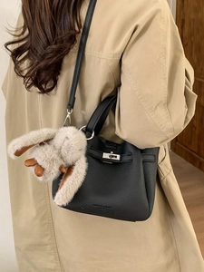 Litchi pattern leather bucket bag with silver twist lock and plush bunny pendant accessory