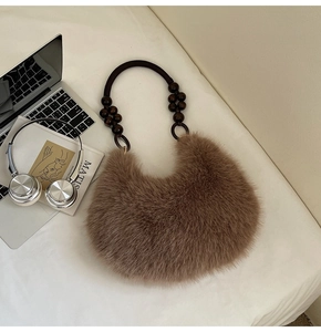 Detail of plush brown moon bag with vintage wooden beaded handle and soft faux fur texture