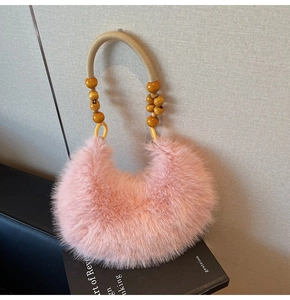Détail du sac à main en fausse fourrure rose pâle avec anse en corde et perles en bois