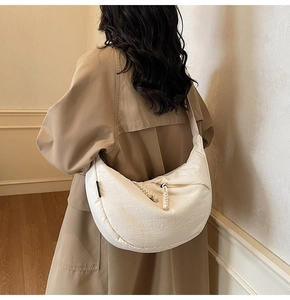 Detailed shot of a white nylon crescent crossbody bag with woven drawstring texture
