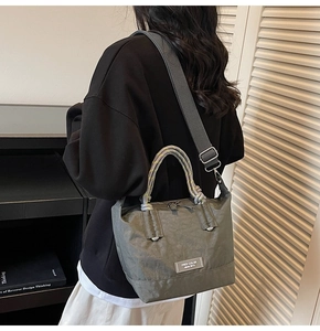Détail du sac seau en toile froissée gris-vert avec poignées en corde et bandoulière tissée