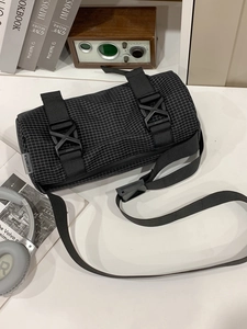 Moderne schwarze Zylindertasche mit Karomuster, Schnallen und breitem Schultergurt