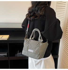 Sac seau vert olive avec anses en corde porté par un mannequin dans un décor intérieur