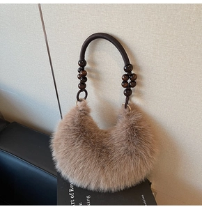 Detailed close-up of brown faux fur handbag with wooden bead accents and braided handle
