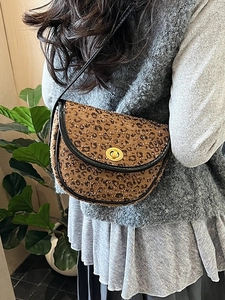 Borsa a sella leopardata con chiusura a scatto dorata e profili in pelle nera