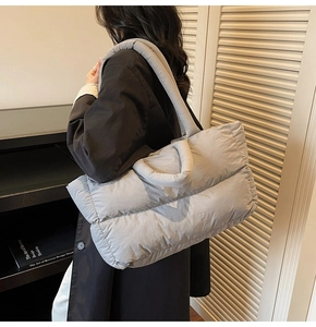 Detail of grey quilted puffer tote bag with thick padded straps and nylon finish