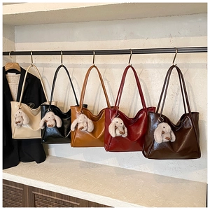 Detailed display of tote bags in five colors with plush rabbit charms on a metal rack