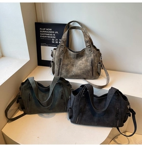 Detail of vintage large tote bags in khaki brown, dark green, and grey soft leather