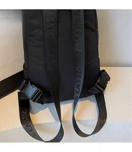 Detail of black puffer backpack with adjustable buckle and FASHION-lettered shoulder strap
