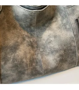 Macro detail of retro matte faux leather texture and reinforced stitching on a large tote bag