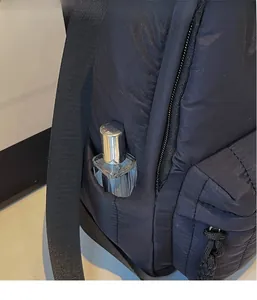 Detailed view of the side open storage pocket on black quilted padded backpack for students