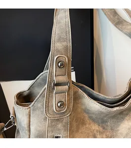 Detailed macro view of vintage grey faux leather tote with metallic rivets and ring buckle