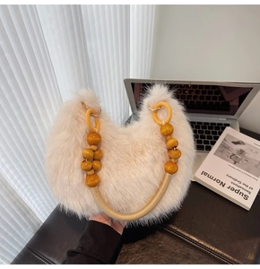 Détail du sac moumoute crème avec anneaux jaunes décoratifs et poignée en perles de bois