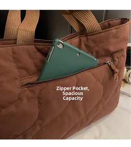 Close-up of brown quilted tote bag detailing a zip pocket and spacious interior