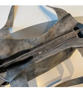 Detail of vintage grey tote bag featuring smooth double metal zipper closure and hardware