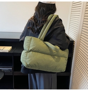 Olive green quilted puffer tote bag shown on model highlighting the large capacity