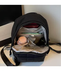 Detail of black nylon backpack with quilted pattern showing spacious inner compartments