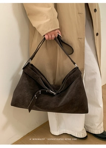 Detail of retro dark brown suede tote bag with stylish silver metal buckle strap