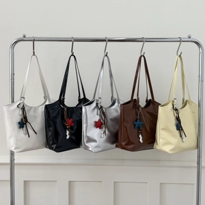 Modern tote bags in five colors hanging on a silver rack with minimalist star charms