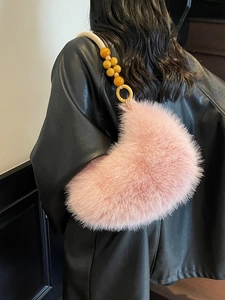 Sac croissant en peluche rose avec poignée artistique et perles jaunes sur manteau en cuir