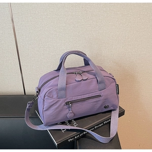Detail of purple nylon Boston bag with double handles and adjustable shoulder strap