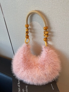 Sac à main croissant en fausse fourrure rose avec poignée en perles tressées