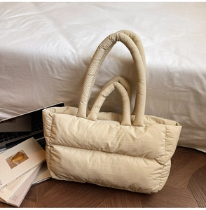 Detailed view of beige quilted tote bag showing padded texture and minimalist design